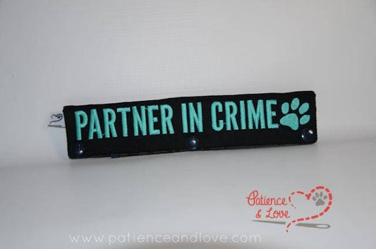 • One Leash Sleeve embroidered with the following on both sides of the sleeve:       Partner in Crime with paw print      Example in the listing photo has the following color selections:        • Black fabric, aqua (1799) text.