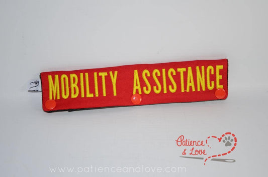  One Leash Sleeve embroidered with the following on both sides of the sleeve:       MOBILITY ASSISTANCE     Example in the photo has the following color selections:  Red fabric, yellow (1924) text.