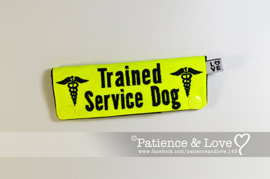 Bright yellow sleeve with black text that says Trained Service Dog with snakes, caduceus