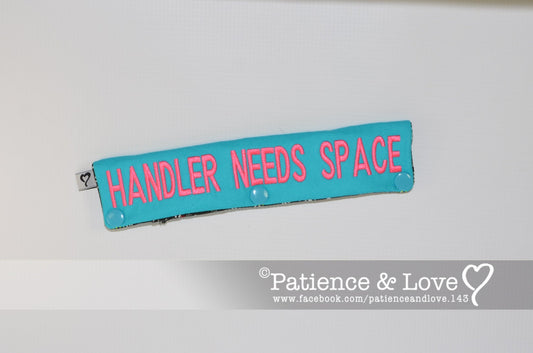 One Leash Sleeve embroidered on both sides of the sleeve with        HANDLER NEEDS SPACE   As seen in the listing photos.   Listing photo shows teal fabric with pink 1909 thread.