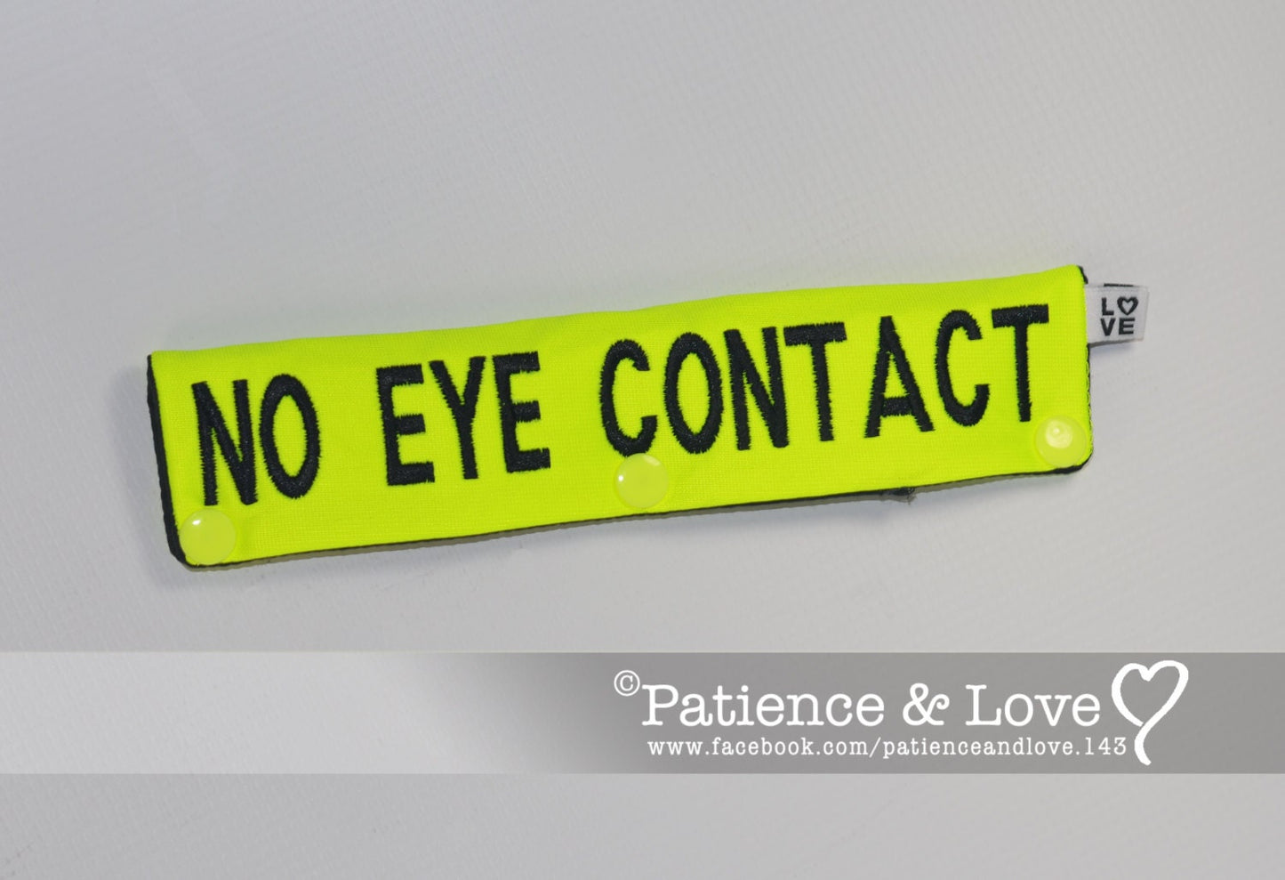 One Leash Sleeve embroidered with the following on both sides of the sleeve:       NO EYE CONTACT     Example in the listing photo has the following color selections:        • Bright yellow fabric, Black (1800) text.