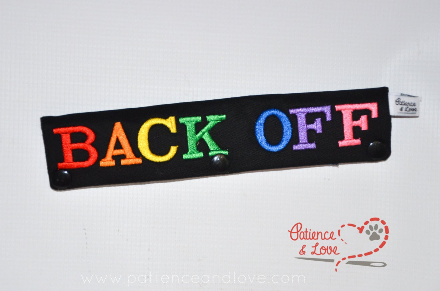 One Leash Sleeve embroidered with the following on both sides of the sleeve       Back Off with rainbow text   As seen in the listing photo.   Listing photo shows black fabric with rainbow text.
